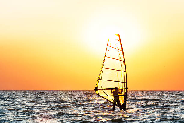 Windsurfing at sunset stock photo