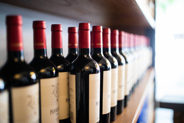 wine bottles on shelf at a winery - vinho imagens e fotografias de stock