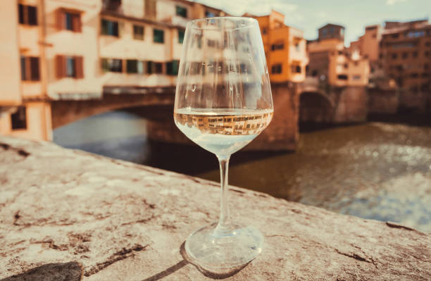 Wine glass and view on bridge Ponte Vecchio in historical Florence, Tuscany. River and ancient cityscape in Italy stock photo