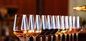 istock Wine glasses in a row. Pouring wine. Buffet table celebration of wine tasting. Nightlife, celebration and entertainment concept 1084996528