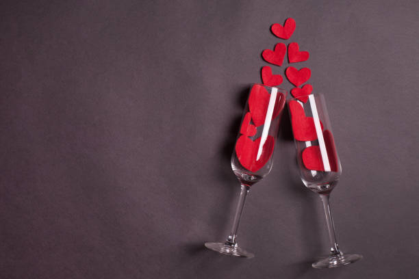 wijnglazen met rood hart op donkere grijze achtergrond - romantiek begrippen stockfoto's en -beelden