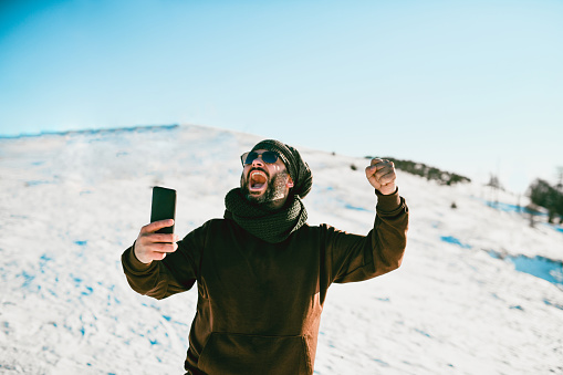 Winner Mentality Shown By Male Shouting While Playing Online Poker Game During Snow Vacation