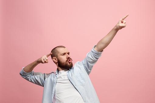 Only forward to victory. Winning success happy man celebrating being a winner. Dynamic image of caucasian male model on pink studio background. Victory, delight concept. Human facial emotions concept. Trendy colors