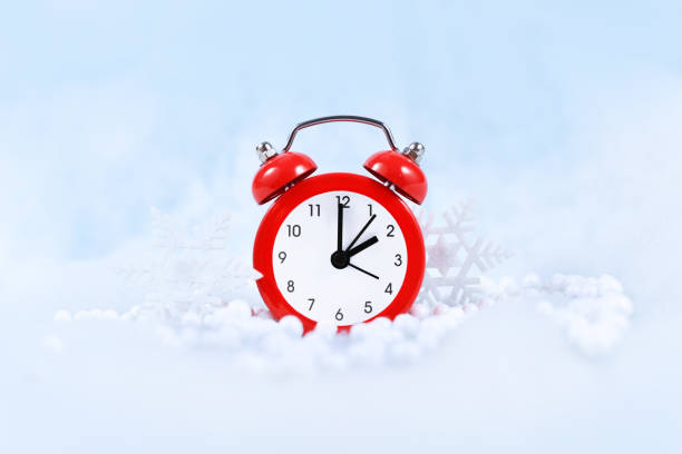 Winter daylight saving time Winter time change for daylight saving in Europe on October 31st concept with red alarm clock between snow daylight savings 2021 stock pictures, royalty-free photos & images