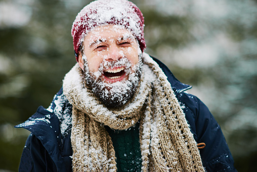 Man laughing with snow on his face