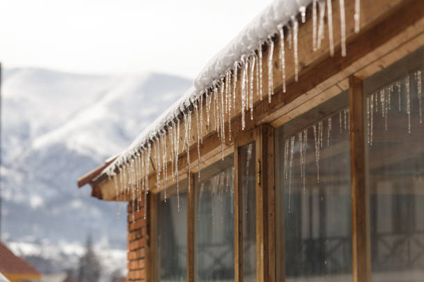Winter icicles hanging from eaves of roof stock photo