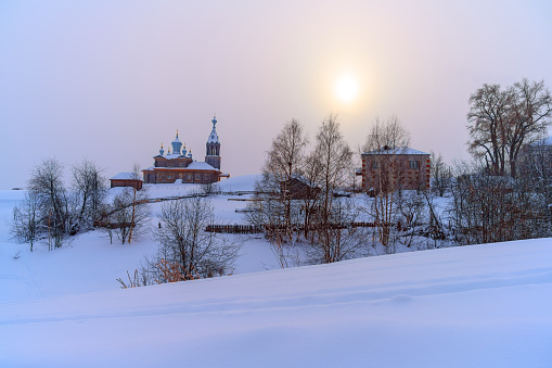 Winter in Cherdyn (Northern Ural, Russia) - a city on three hills. A thick layer of even clean snow covered the mountains, ancient churches, buildings and trees. Light fog descended due to severe frost