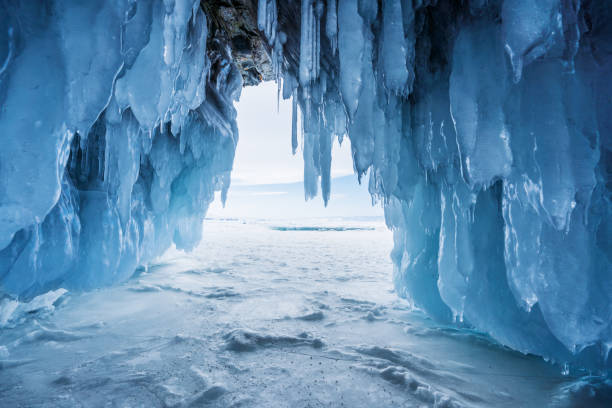 winter landschap, bevroren ijsgrot met fel zonlicht van uitweg op het baikalmeer in irkutsk, rusland - stalactiet stockfoto's en -beelden
