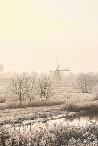 View on an old windmill in the city of Kampen next to the river IJssel in winter in Holland. Kampen is an ancient Hanseatic League in Overijssel, The Netherlands.