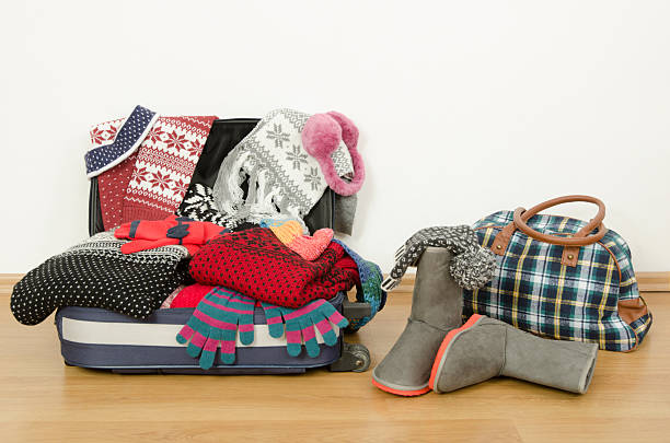 Winter luggage. Suitcase full of wither clothes. stock photo