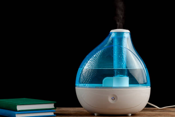 Winter night, cold, flu concepts with an ultrasonic air humidifier creating cool mist water vapor. stock photo