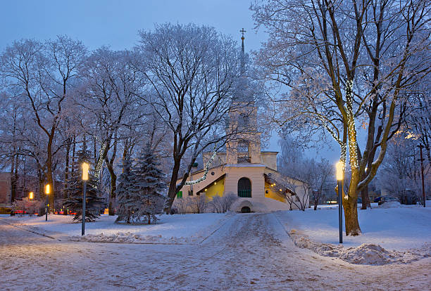 Winter park with Christmas decorations and old church, Pskov, Russia Winter park with Christmas decorations and old church in Pskov, Russia at dusk pskov russia stock pictures, royalty-free photos & images