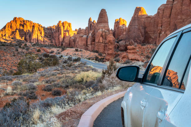 Winter sunrise driving in Arches National Park Winter sunrise driving on a highway through Arches National Park near Moab in Utah, travel, recreation and vacation concept. arches national park stock pictures, royalty-free photos & images