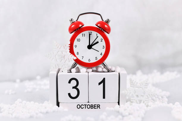 Winter time change concept Time change for daylight saving winter time in Europe on October 31st concept with red alarm clock and calendar in snow daylight savings time 2021 stock pictures, royalty-free photos & images