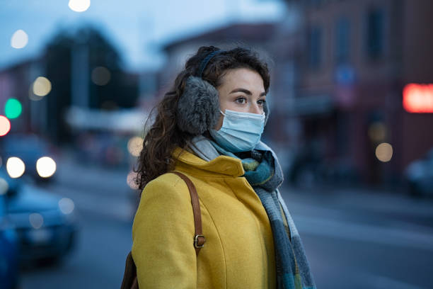 도시 거리에서 마스크를 착용하는 겨울 여성 - 귀덮개 뉴스 사진 이미지