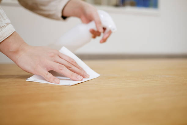 Wiping on the desk to prevent infectious virus Family life during covid-19 clean desk stock pictures, royalty-free photos & images