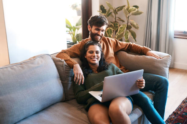 Wireless entertainment for a lazy day at home Shot of a young couple using a laptop while relaxing on the sofa at home free images for downloads stock pictures, royalty-free photos & images