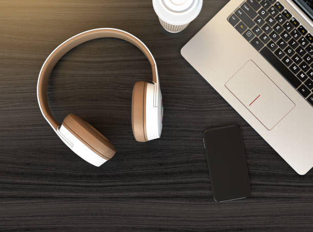 Wireless headphone, laptop PC on dark wooden table stock photo