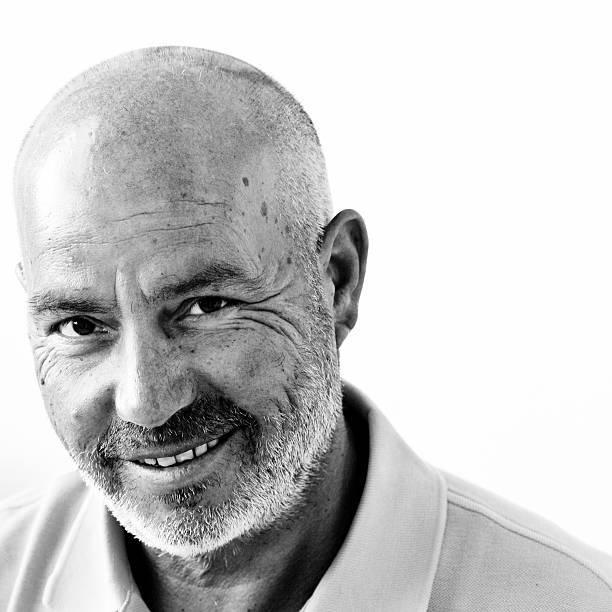a wise bald happy man posing for a photo - zwart wit stockfoto's en -beelden