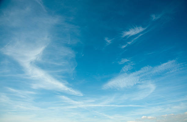 Wispy Cloud Background Wispy clouds on a blue sky background. wispy stock pictures, royalty-free photos & images