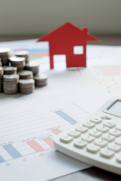 With House Model And Stack Of Coins On Desk stock photo