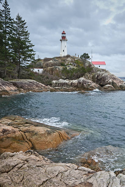 Point Atkinson Lighthouse and Rocky Shore With the advent of radar, GPS and other advanced navigation tools, lighthouses no longer need to perform the same function they once did; guiding ships to safety. Instead they have been preserved as historic monuments; reminding us of a time when shipping and sailing were more perilous activities. The Point Atkinson Lighthouse is located at Lighthouse Park in West Vancouver, British Columbia, Canada. jeff goulden lighthouse stock pictures, royalty-free photos & images
