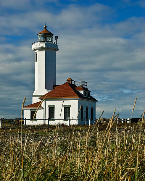 Point Wilson Lighthouse with Dead Grass With the advent of radar, GPS and other advanced navigation tools, lighthouses no longer need to perform the same function they once did; guiding ships to safety. Instead they have been preserved as historic monuments; reminding us of a time when shipping and sailing were more perilous activities. The Point Wilson Lighthouse is located at Fort Worden State Park near Port Townsend, Washington State, USA. jeff goulden lighthouse stock pictures, royalty-free photos & images