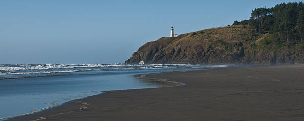 North Head Lighthouse and the Pacific Ocean With the advent of radar, GPS and other advanced navigation tools, lighthouses no longer need to perform the same function they once did; guiding ships to safety. Instead they have been preserved as historic monuments; reminding us of a time when shipping and sailing were more perilous activities. The North Head Lighthouse is located at Cape Disappointment State Park near Ilwaco, Washington State, USA. jeff goulden seascape stock pictures, royalty-free photos & images