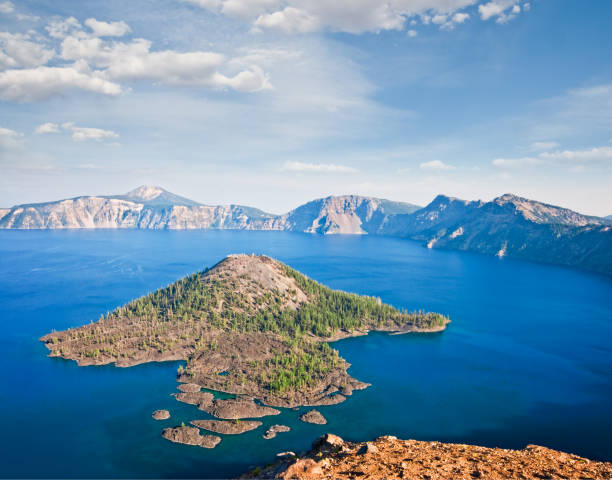 Wizard Island and Crater Lake Crater Lake exists in the blown-out caldera of a once mighty volcano known as Mount Mazama. This view of the lake and Wizard Island was photographed from Watchman Overlook in Crater Lake National Park, Oregon, USA. jeff goulden crater lake national park stock pictures, royalty-free photos & images