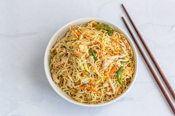 Wok Tossed Chicken Noodles with Chopsticks Top Down Asian Food Photo stock photo