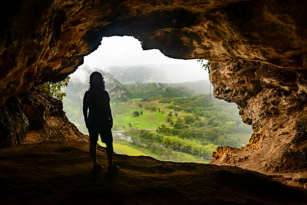 Woman admiring the view from Window Cave in Puerto Rico. Woman admiring the view from Window Cave (Cueva Ventana) in Puerto Rico. Cueva Ventana ("Cave Window") is a large cave situated a top a limestone cliff in Arecibo, Puerto Rico, overlooking the Río Grande de Arecibo valley. puerto rican women stock pictures, royalty-free photos & images