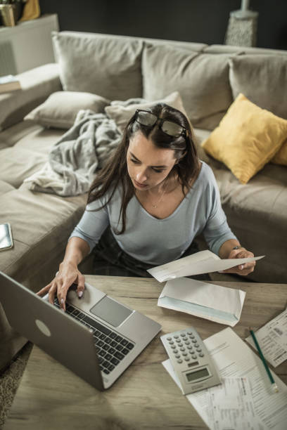 Woman analyzing documents while sitting at home stock photo