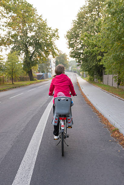 Woman and her baby traveling by bicycle stock photo