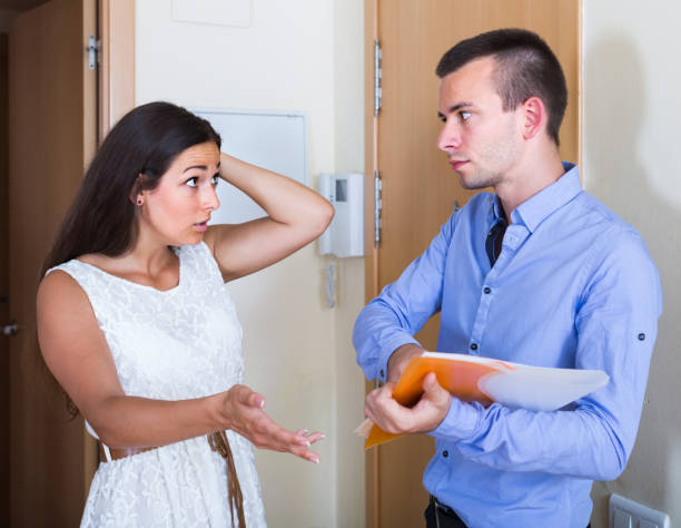 woman and man having argue with documents at doorway Young woman and man having argue with documents at doorway landlord stock pictures, royalty-free photos & images