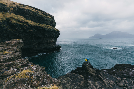 Young Caucasian woman and man   looking at scenic  view from hill on Faroe Islands