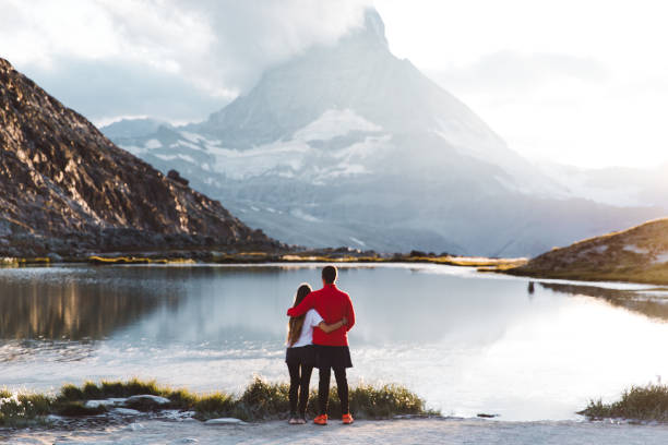 Photo of Woman and man meet sunset at the beautiful mountain lake in Swiss Alps