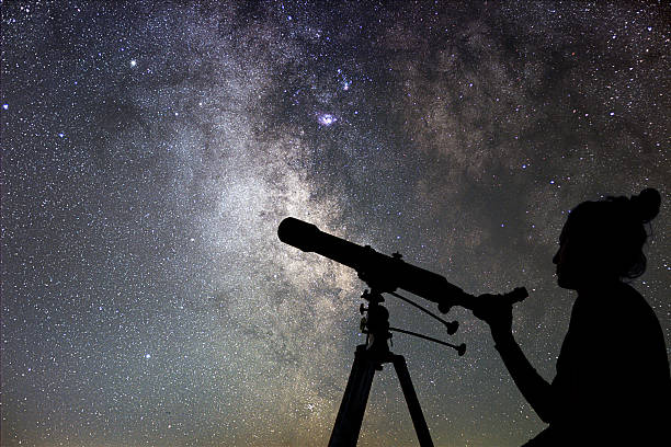 woman and night sky. watching the stars woman with telescope. - milky way imagens e fotografias de stock