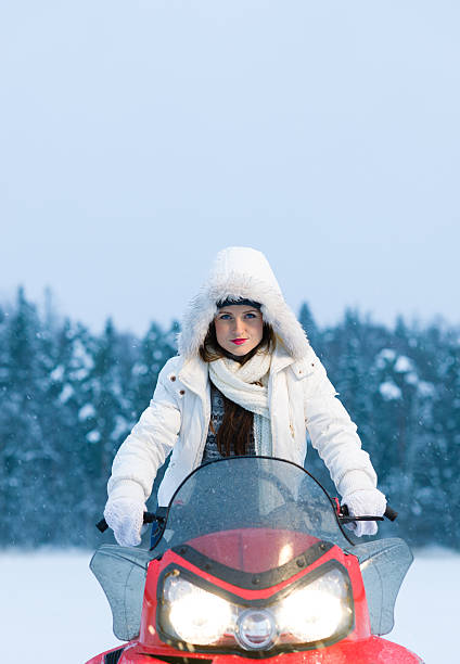 Woman and snowmobile stock photo