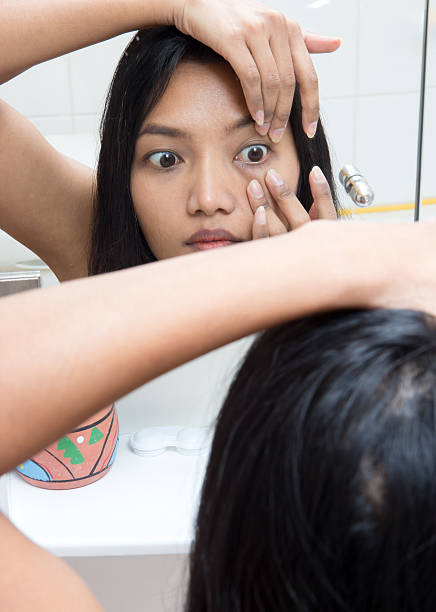 woman applying contact lens stock photo