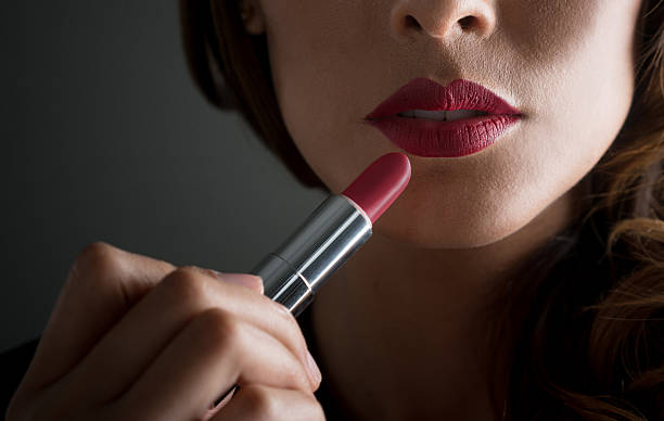 Woman applying red lipstick Close-up on  a woman applying red lipstick on her lips straight from the bullet - makeup concepts woman red lipstick stock pictures, royalty-free photos & images
