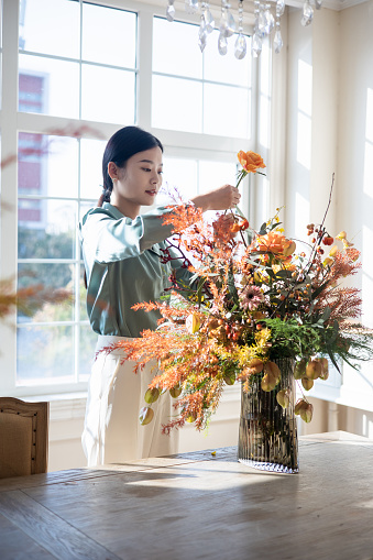 Woman arranging flowers at home
