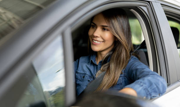 Woman at a showroom going for a test drive in a car Portrait of a happy woman at a showroom going for a test drive in a car and smiling driving stock pictures, royalty-free photos & images