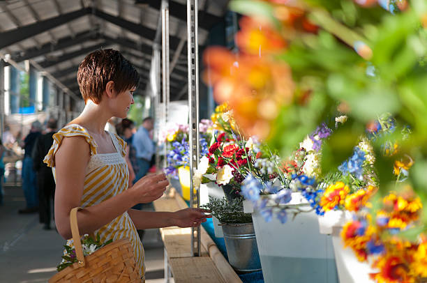 Woman at farmers market with flowers stock photo