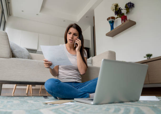 Woman at home complaining about a bill on the phone Latin American woman at home complaining about a bill over the phone - customer service concepts complaining stock pictures, royalty-free photos & images