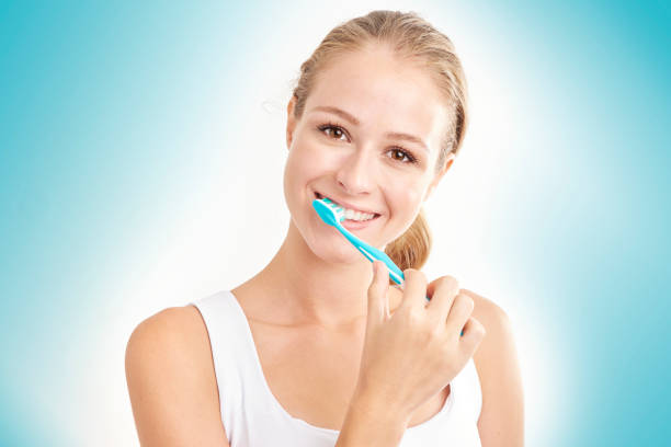 Woman brushing her teeth stock photo