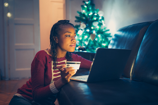 African American woman buying Christmas gifts online