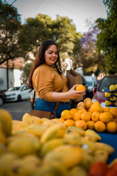 Woman buying orange at the local market stock photo
