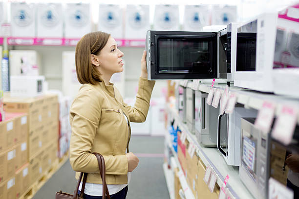 woman buys the microwave stock photo