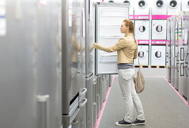 woman buys the refrigerator in shop stock photo