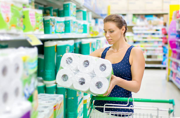 woman buys toilet paper in the supermarket stock photo